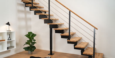 A staircase with a sleek, minimalist handrail banister, combining wood and metal for a contemporary look.