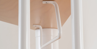 Close-up of staircase accessories, including a raiser bar for secure installation.