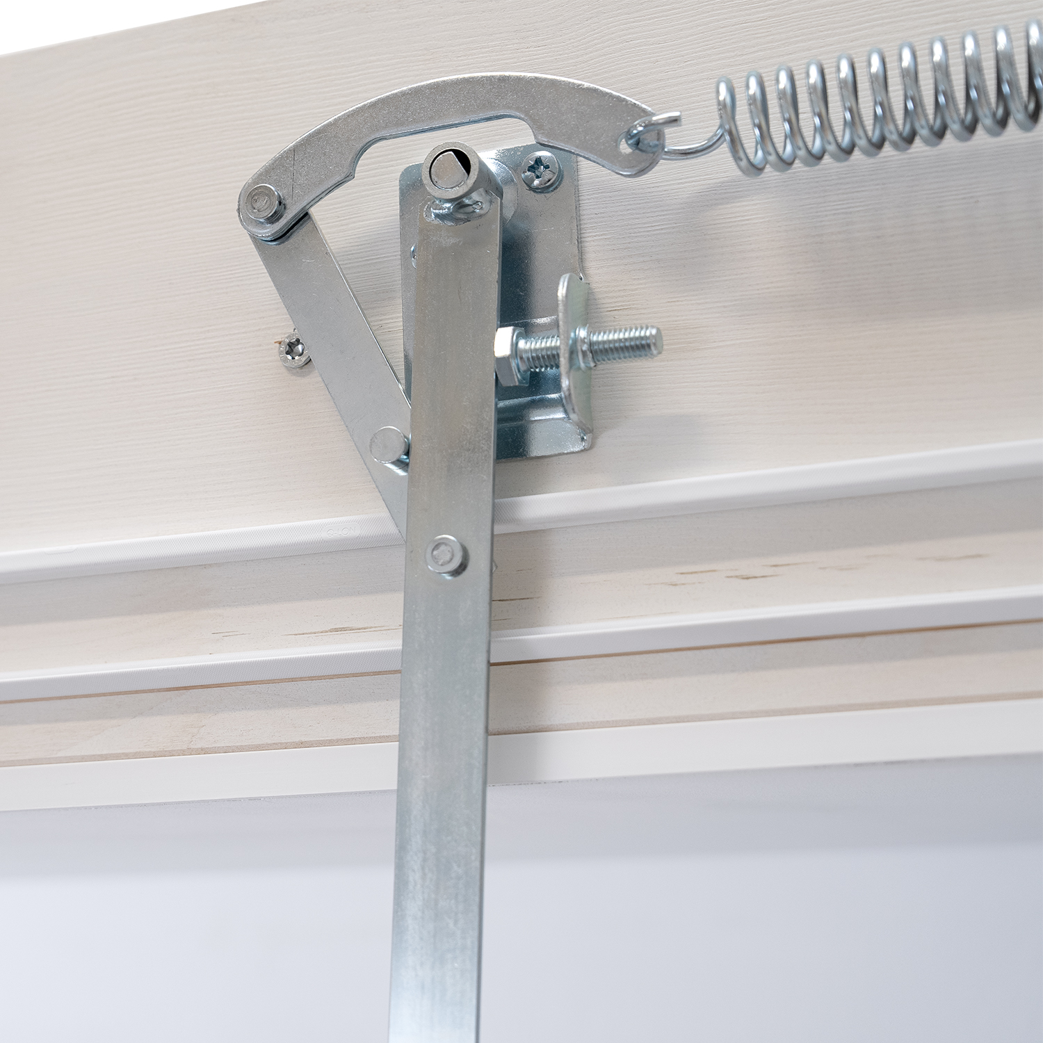 Detailed view of a spring-assisted hinge system on a loft ladder installation.