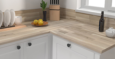 Modern kitchen counter with light wood worktops, accessorized with jars and utensils for a natural, functional aesthetic